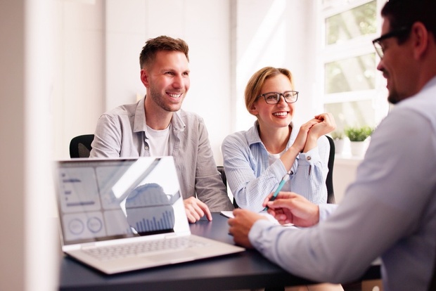 A couple happily talking with their financial planner.